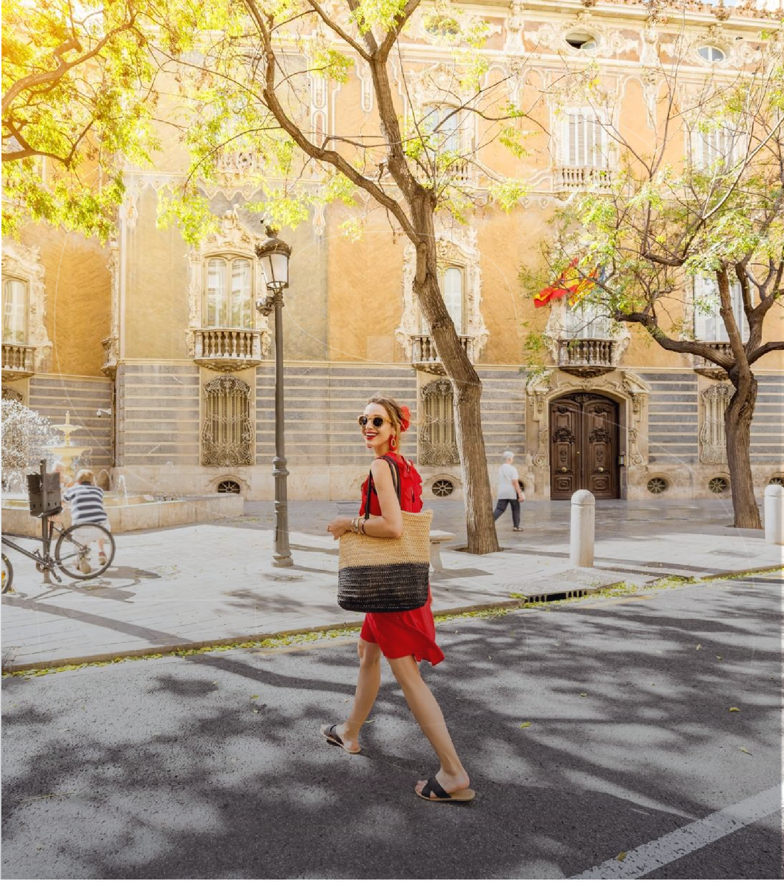 Woman in a red dress walking down a street in Valencia with ornate architecture