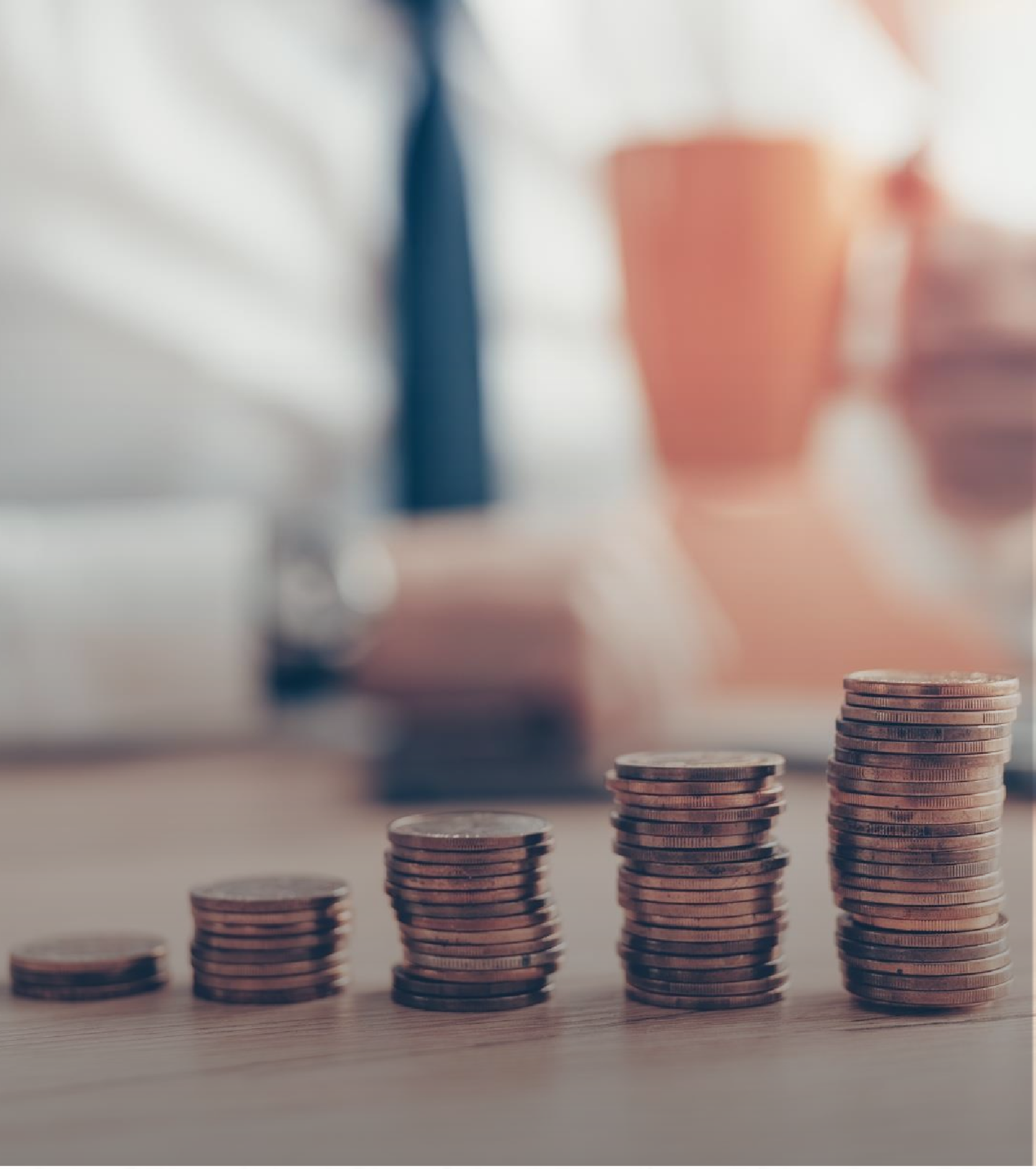 Ascending stacks of coins symbolizing income growth on a wooden desk